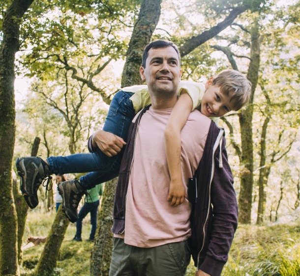 Father-carrying-son-in-woods