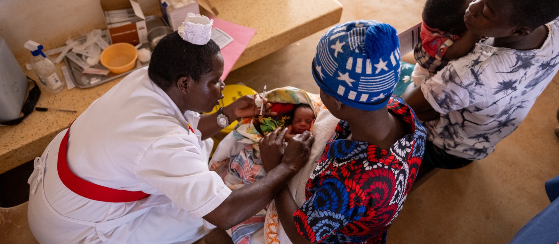 Nurse giving a vaccination to infant.