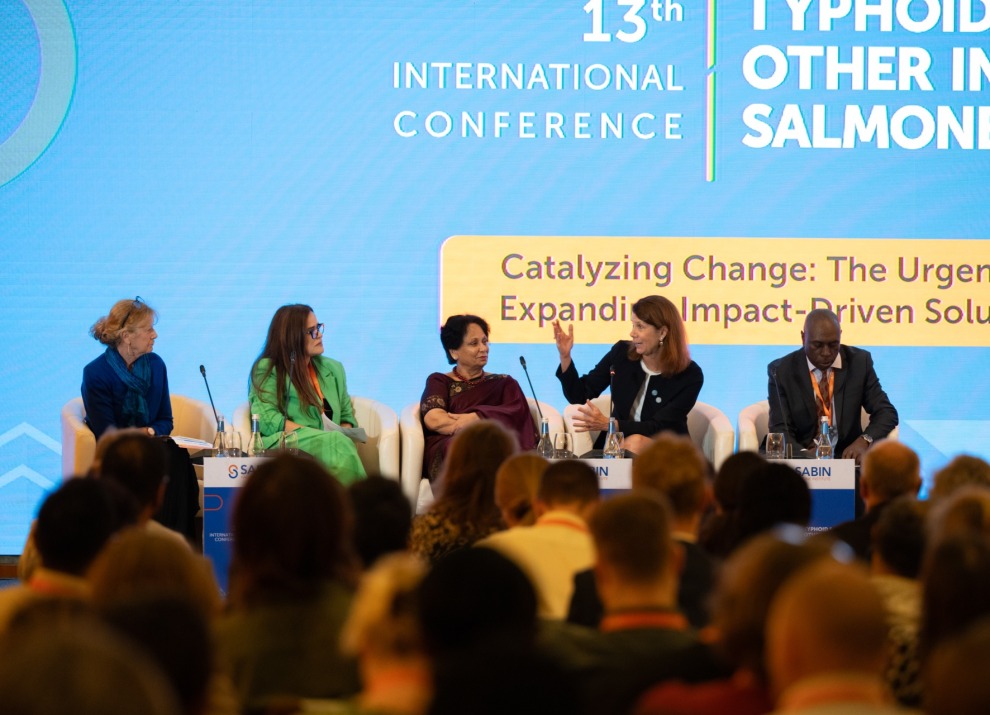 A panel discussion on stage at a conference.